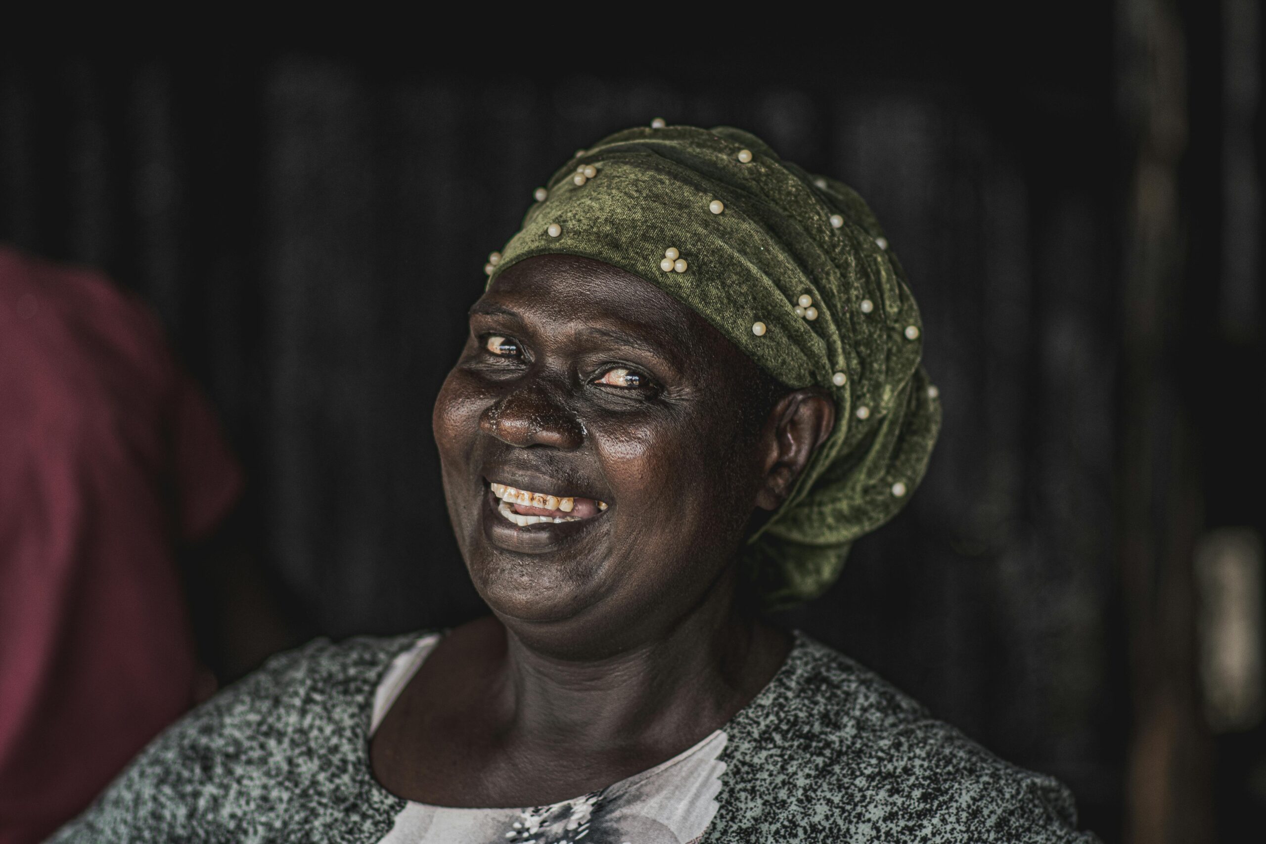 Portrait of a smiling African woman with headscarf, showcasing joy and cultural fashion in Nairobi, Kenya.